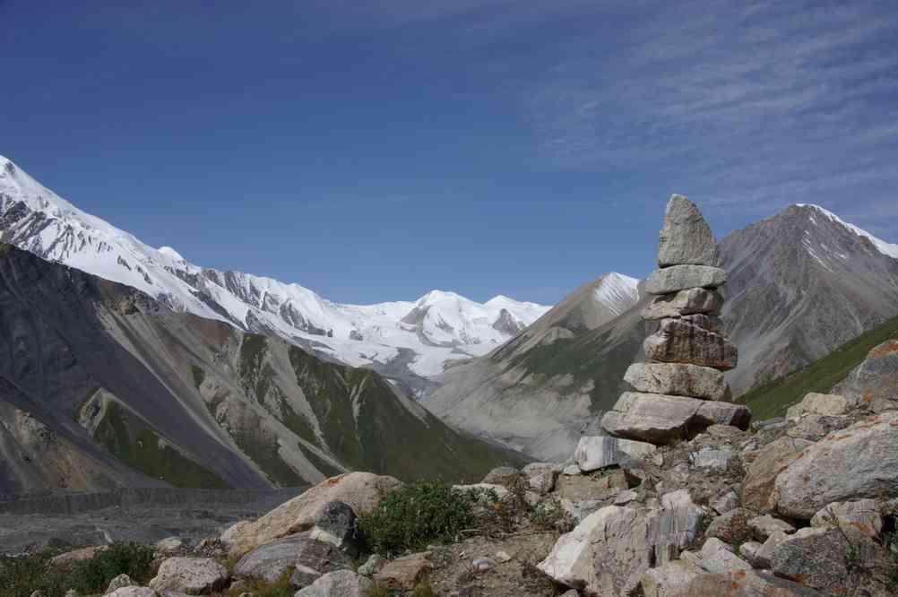 Cairn caractéristique sur le sentier vers le col Chinois (col Kitaiski (Китаиски)) : vue sur le pic Odinnadzaty (5437 m), le pic Adishev (4651 m) et le pic Sigitov (Сигитов) (4730 m). Le 18 août 2009