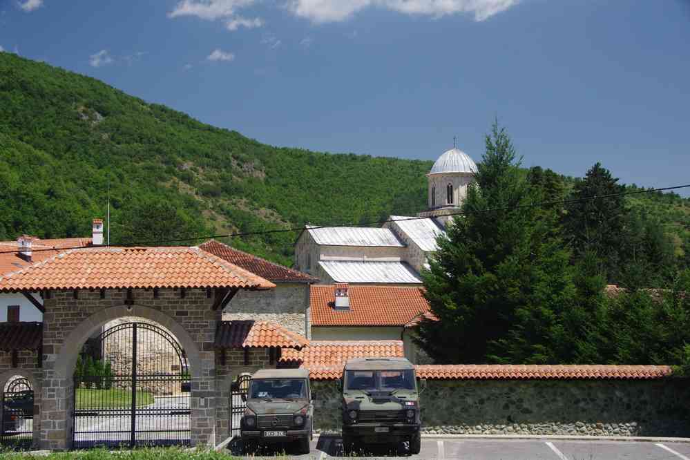 Véhicules de la KFOR stationnés devant le monastère de Dečani, le 14 juillet 2016