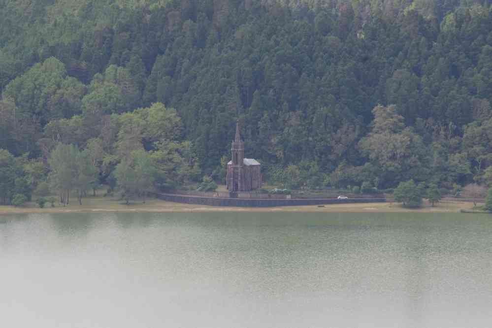 Le lac de Furnas vu depuis le pico do Ferro. Vue au téléobjectif sur la propriété de José do Canto, un riche botaniste du XIXᵉ siècle qui a acclimaté nombre d’espèces végétales dans les Açores → chapelle néogothique de Nossa Senhora das Vitórias, le 3 juillet 2023