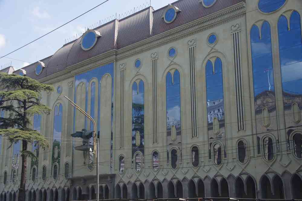 Tbilissi (თბილისი), balade sur l’avenue Roustavéli (რუსთაველის გამზირი). Bâtiment moderne situé en face du parlement dont on devine le reflet, le 11 août 2017