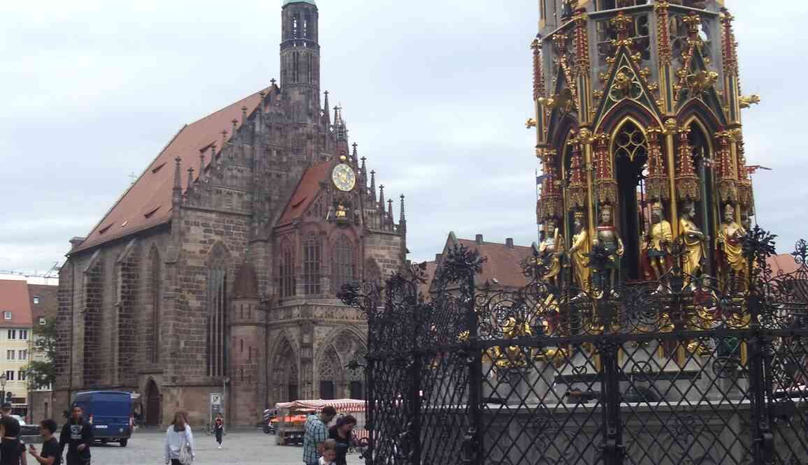 Nuremberg, place du Marché et Frauenkirche (église catholique Notre-Dame). À droite la Belle fontaine (Schöne Brunnen), œuvre de Heinrich Beheim de 1385 à 1396. Il s’agit d’une copie installée en 1912 et qui a résisté aux bombardements. 17 août 2019