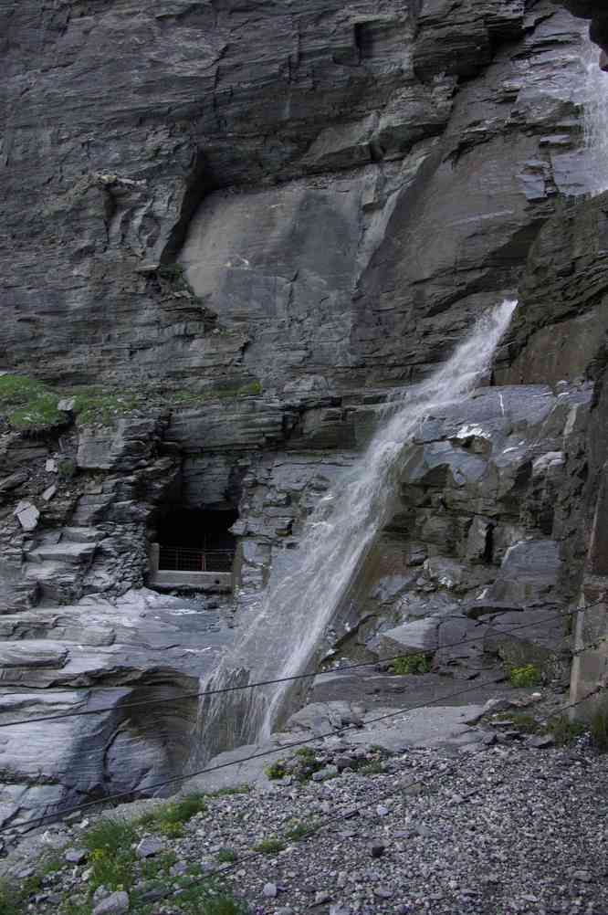 Sentier en tunnel sous une petite cascade